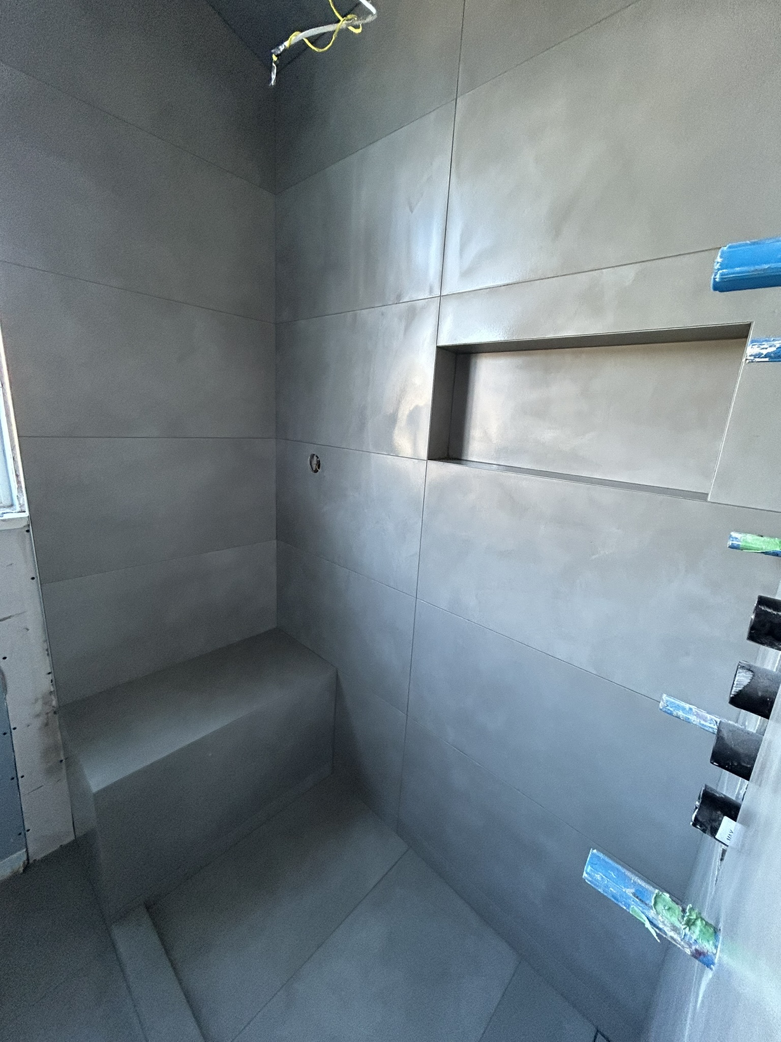 Dark grey walk-in shower with bench and niche