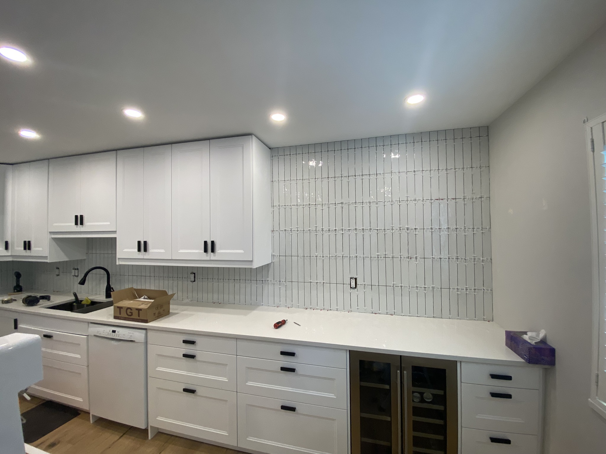 White kitchen with vertical glass tile backsplash