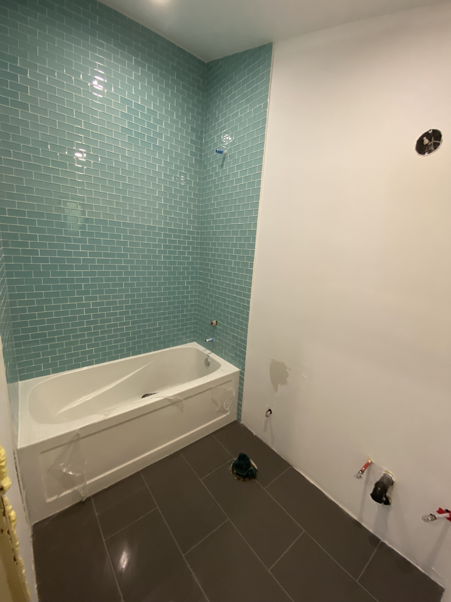 Teal glass subway tile tub surround
