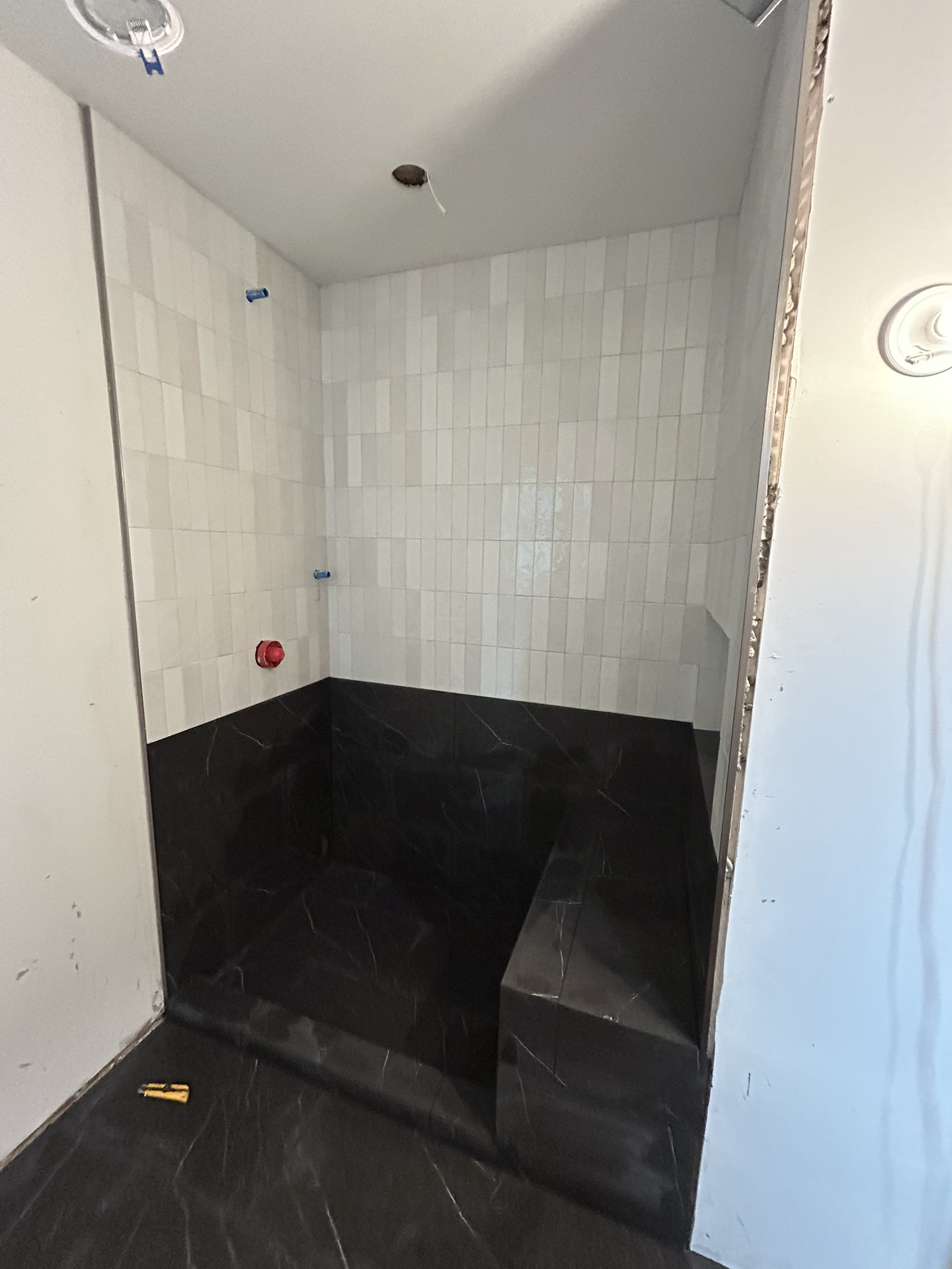 Black and white zellige shower with bench