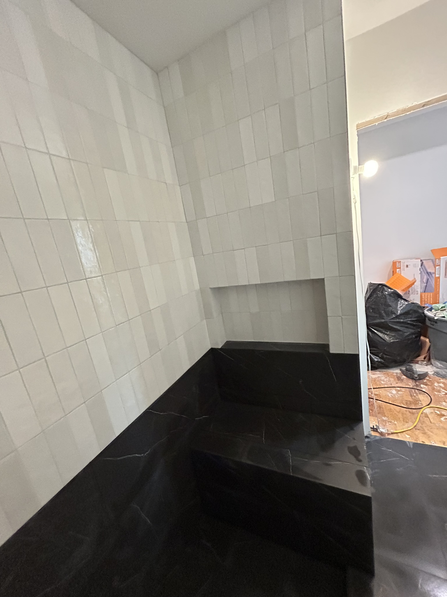 White zellige shower walls with black floor