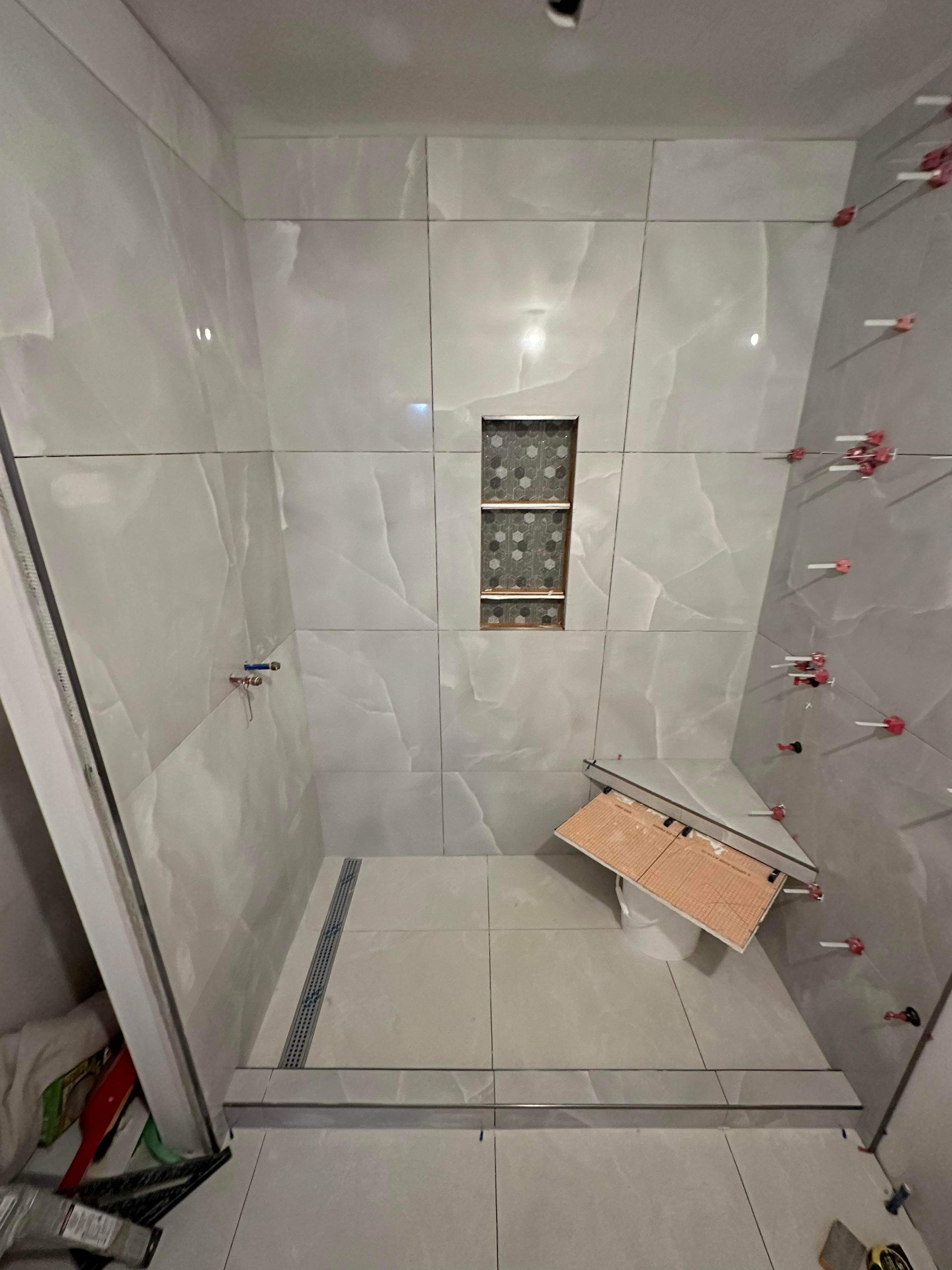 White sculptured tile shower with hex niche