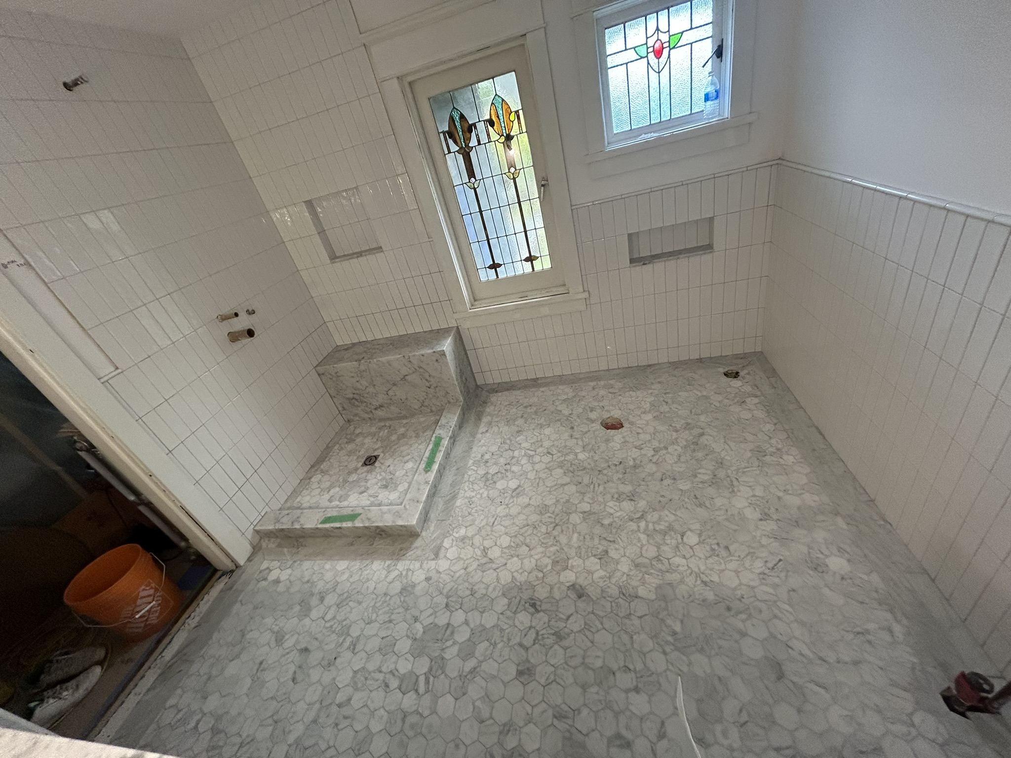 Marble hex floor bathroom with white subway tile