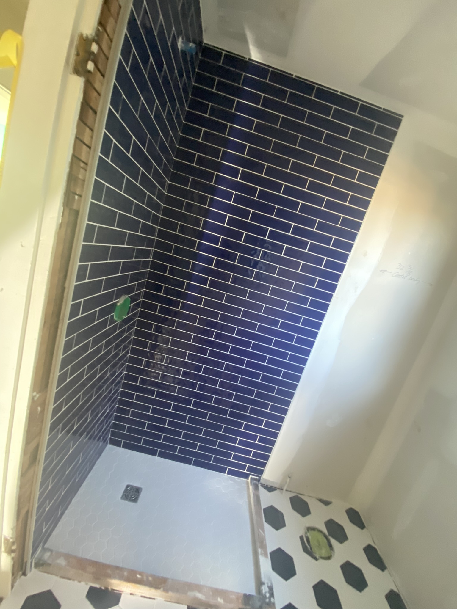 Navy blue subway tile shower with hex floor