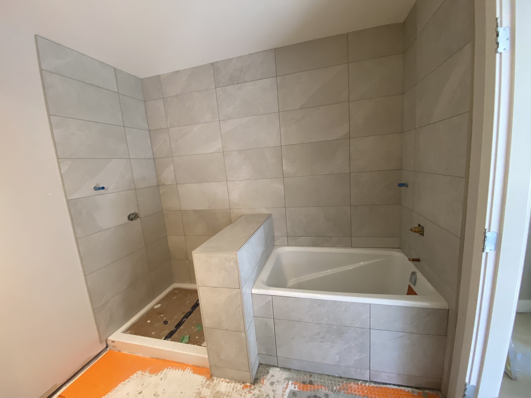 Beige large format tub and shower combo