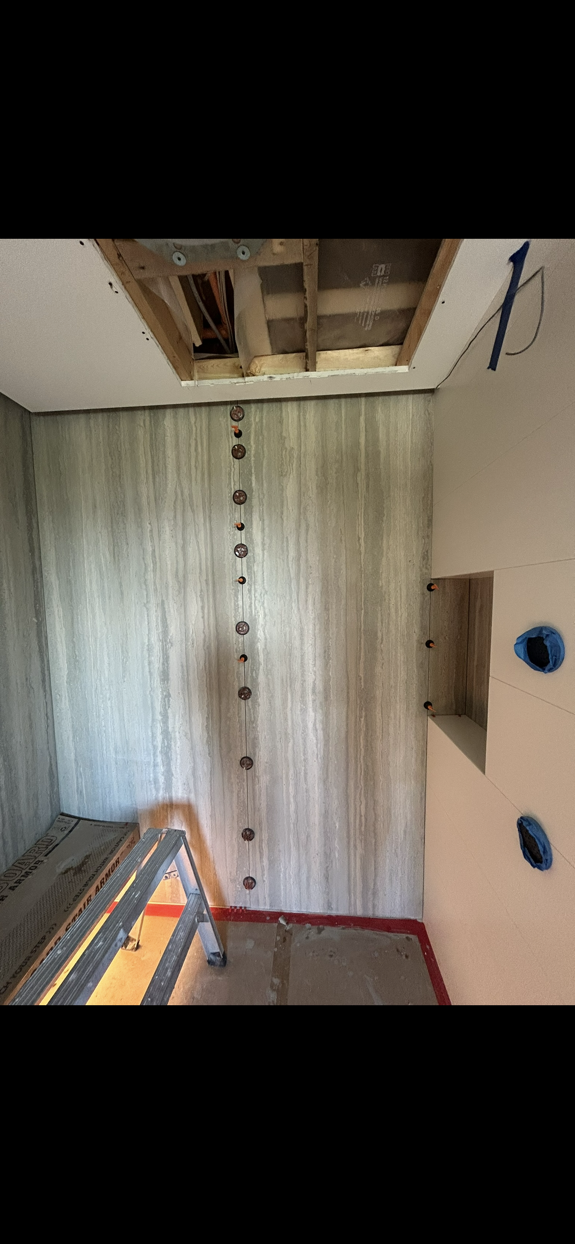 Floor to ceiling linear travertine shower wall