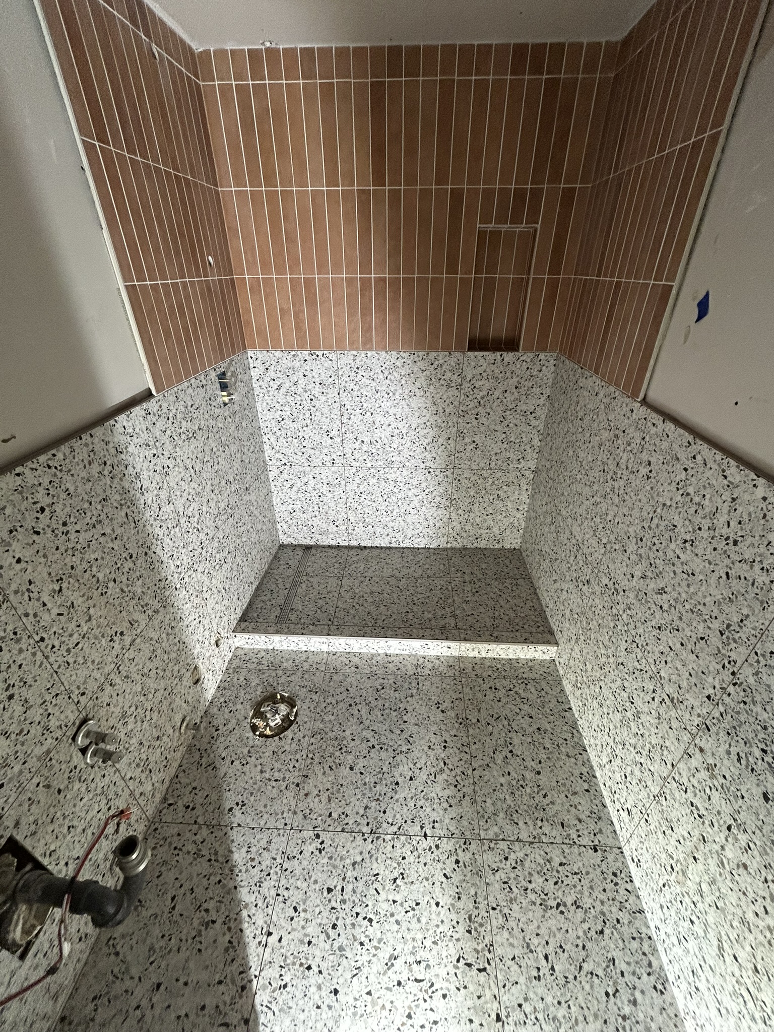 Terrazzo tile shower with terracotta vertical tile